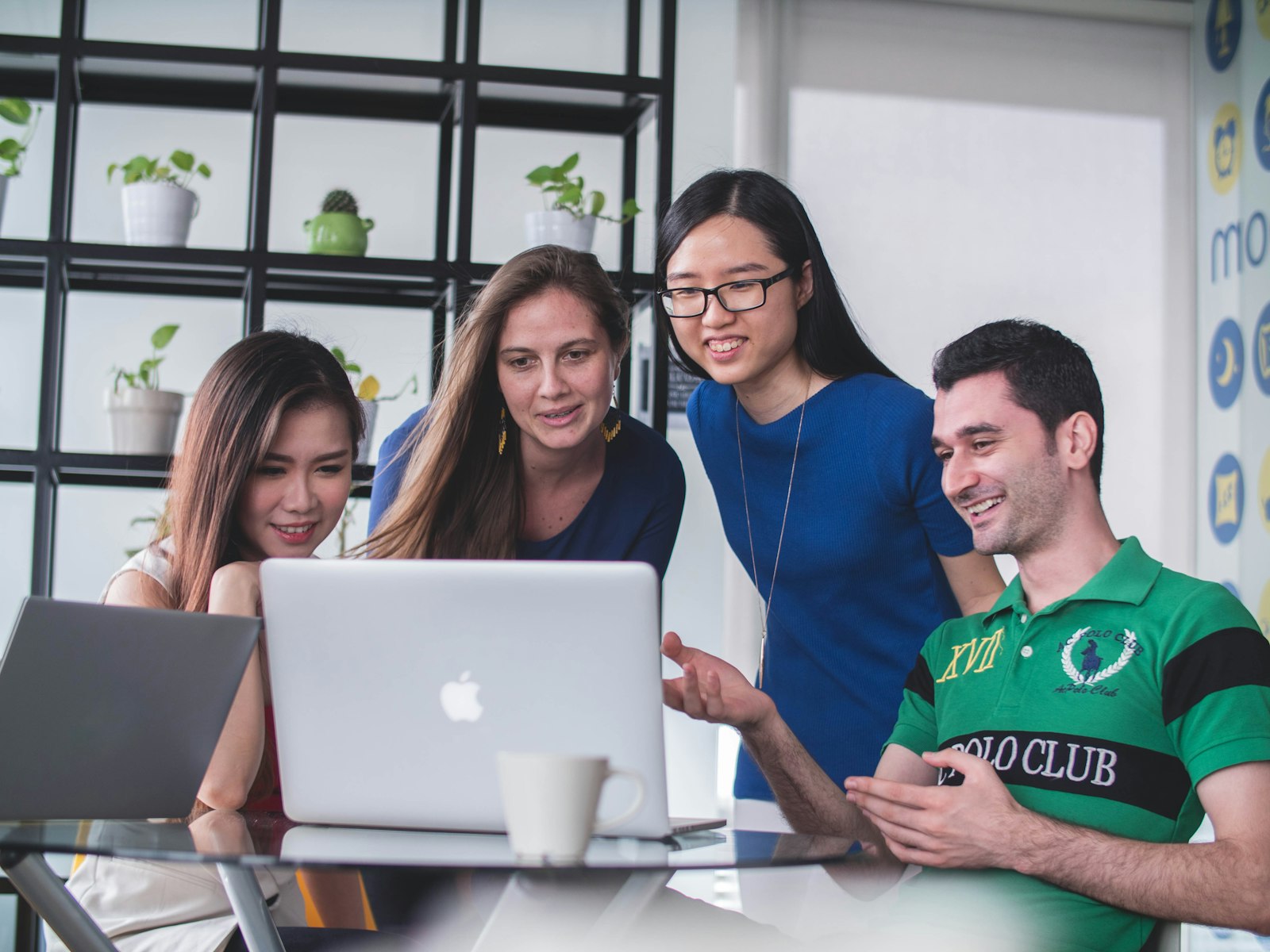 Tres mujeres mirando juntas la pantalla de una laptop mientras aprenden en equipo